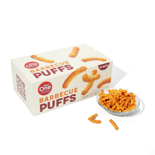Box of Step One Foods Barbecue Puffs with a bowl of puffs on a white background