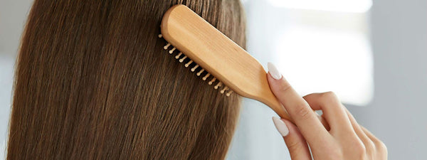 Biotin supplement capsules beside a hairbrush