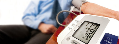 Patient using arm cuff blood pressure monitor