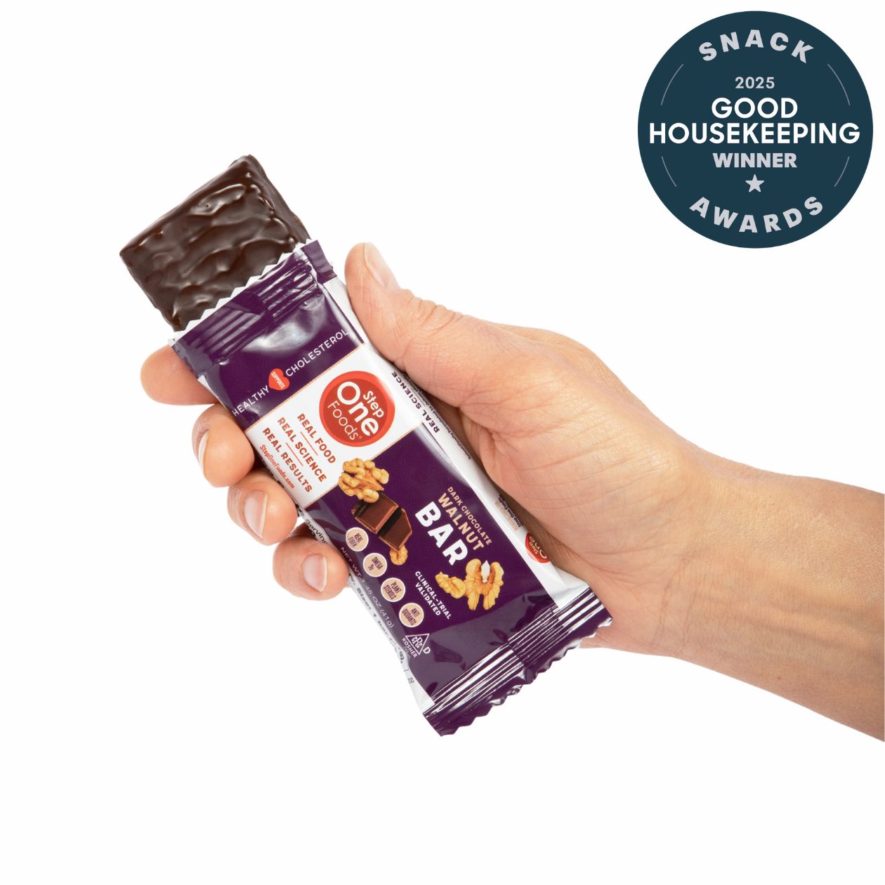 Hand holding a chocolate bar with a Good Housekeeping Award badge on a white background